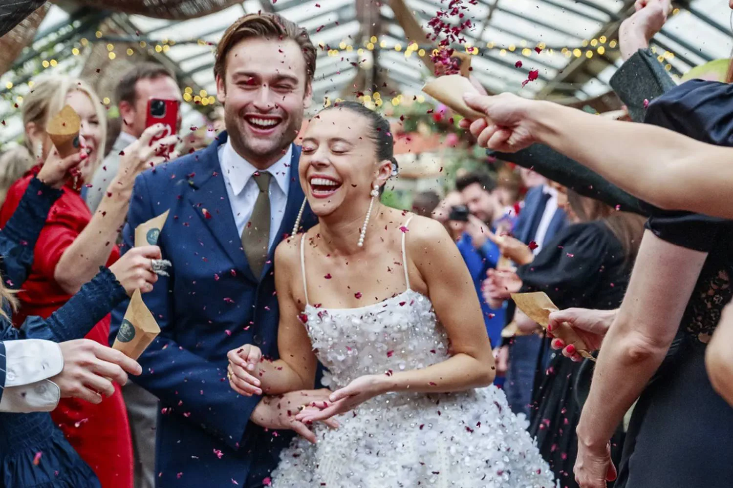 Bel Powley marries Douglas Booth in a custom Miu Miu wedding gown and  reception dress. She chose a simple shape: thin straps and square neck,  tight bodice, and bell-shaped skirt stopping at