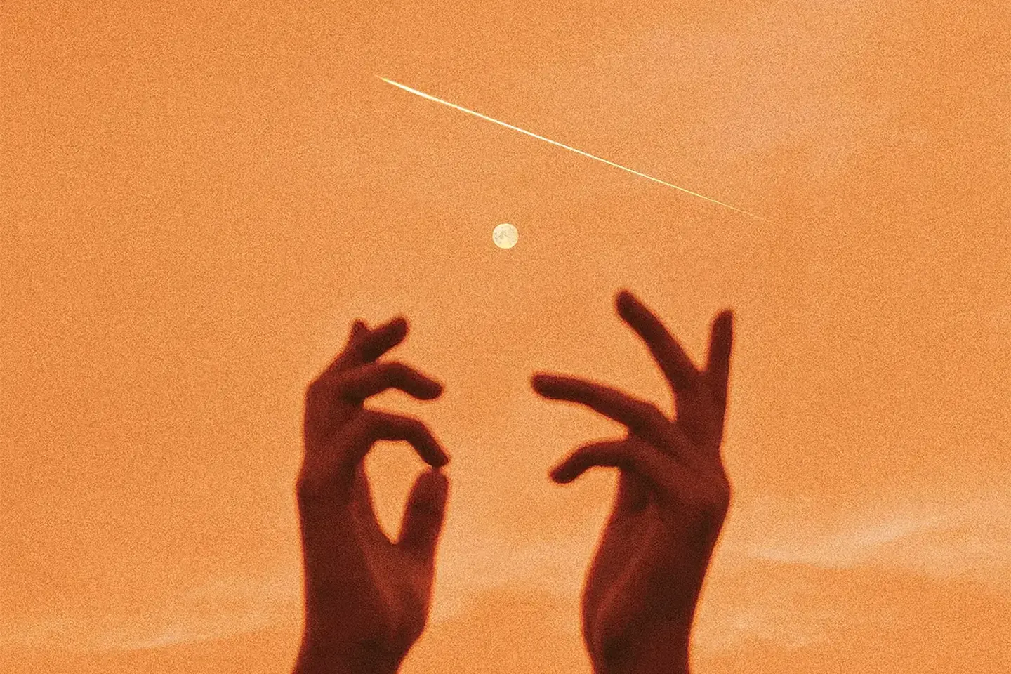 Two hands reaching towards each other against a backdrop of a glowing full moon and starry night sky, representing love and spiritual connection.