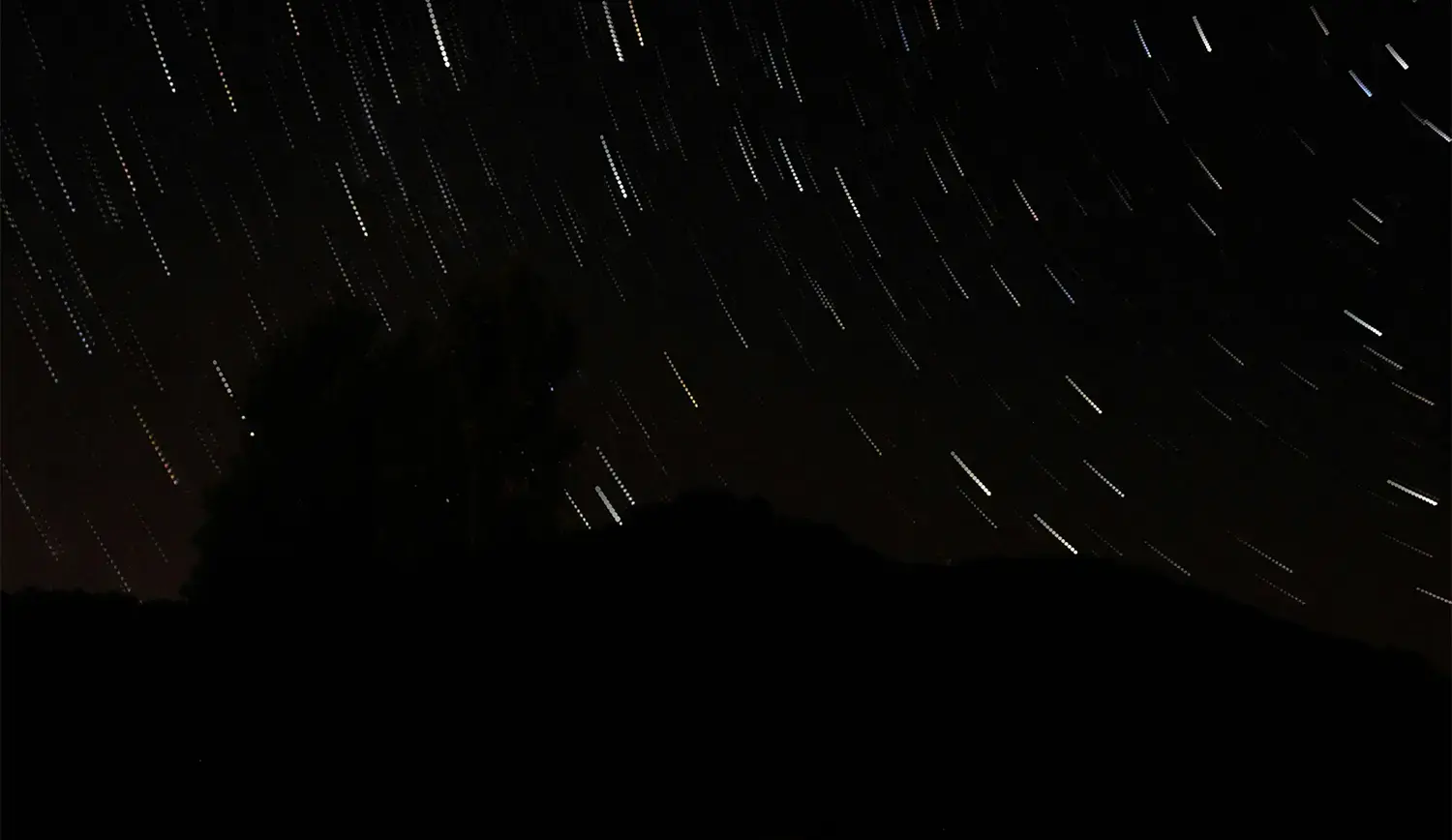 Motion-blurred starry night sky creating the illusion of shooting stars, symbolizing the power of love manifestation and the universe aligning with your intentions.